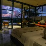 A bedroom with a large bed sitting next to a window