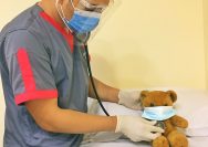man in blue polo shirt wearing white mask holding brown bread