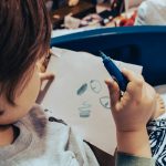 a child drawing on a white paper