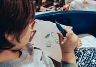 a child drawing on a white paper