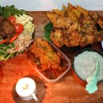 a wooden table topped with bowls of food