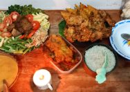 a wooden table topped with bowls of food