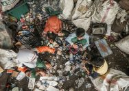 A pile of garbage with people standing around it