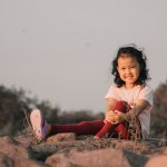 a girl sitting on a rock