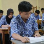 Students are taking a test in a classroom.