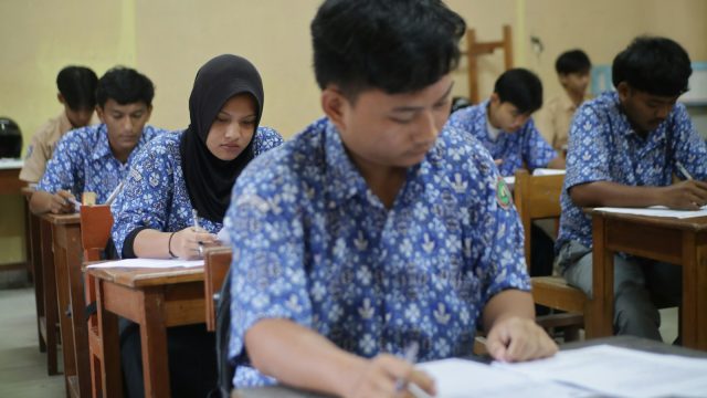 Students are taking a test in a classroom.
