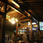 a restaurant with stained glass windows and a wooden ceiling