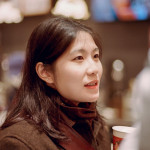 A woman holding a cup of coffee in her hand