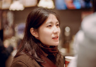 A woman holding a cup of coffee in her hand